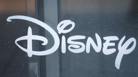 어두운 유리창 표면에 흰색 필기체로 적힌 디즈니(Disney) 로고가 크게 찍혀 있다.