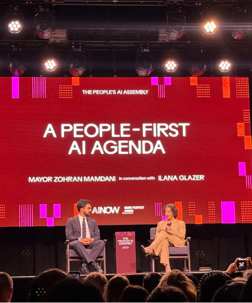 붉은색 대형 화면에 'A PEOPLE-FIRST AI AGENDA' 등의 흰색 영문 문구가 띄워진 무대 아래에서 정장을 입은 두 인물이 의자에 앉아 대담하고 있다.